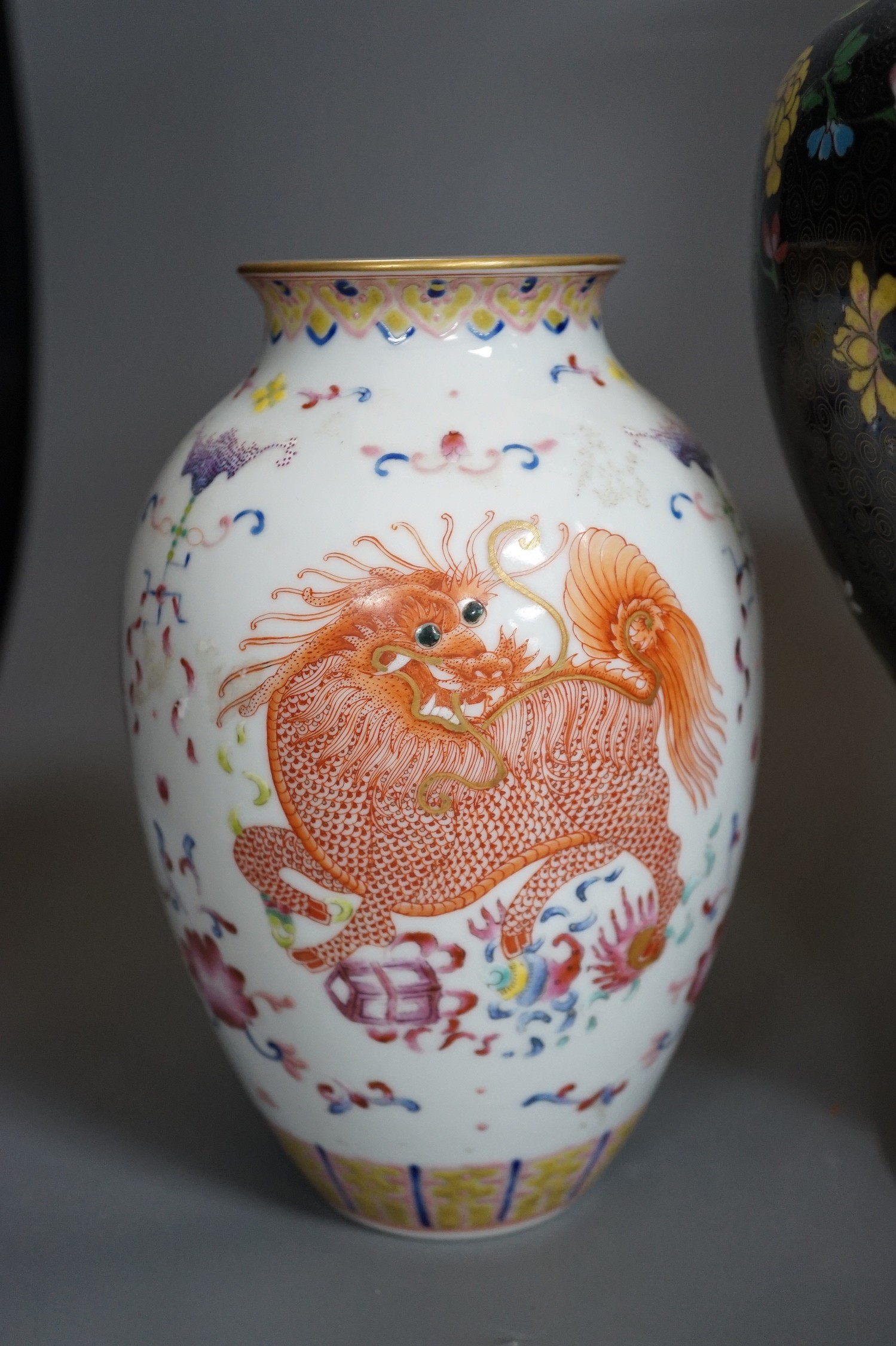 Two Chinese cloisonné enamel vases, and a porcelain ‘lion dog’ vase, tallest 33cm